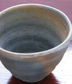 荒石混じりの渋い陶器(土物)と指の跡を大胆に残した手作りのフォルムが野趣溢れるカップです。